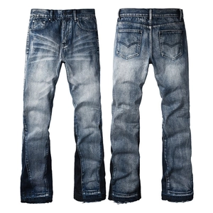 Detail of dark blue flared jeans showing distressed wash patterns and bicolor patchwork design