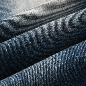 Detailed macro view of dark blue denim fabric texture and washed twill pattern