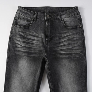 Détail d'un jean en denim délavé gris foncé avec poches classiques et boutons métalliques