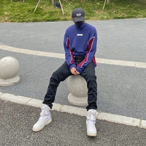 Detail of slim-fit cargo pants styled with white high-top sneakers and contrast hoodie