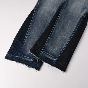 Detailed macro view of two-tone spliced denim hem with vintage raw edge finish