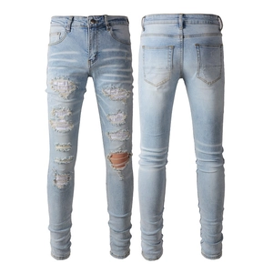 Jean slim bleu clair pour homme avec déchirures, détails strass et effet délavé