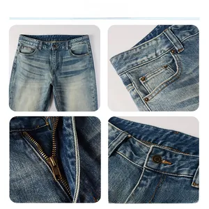 Detailed close-up of light blue washed denim with metal zipper and copper button closure