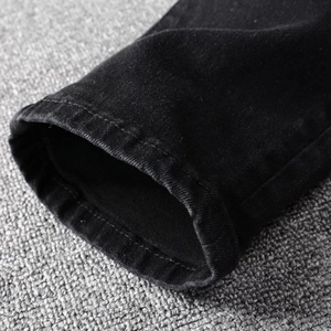 Macro detail of high-quality twill denim texture and precise stitching on black jeans
