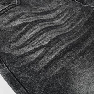 Détail du jean évasé gris anthracite avec effets de délavage moustaches vintage