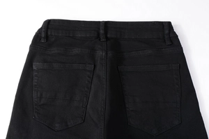 Détail des poches arrière d'un jean noir avec coutures de renfort de haute qualité