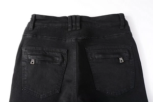 Detail view of black biker jeans showing elastic pleated waist and rear zipper pocket