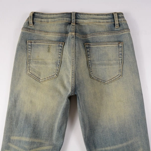 Detail view of vintage washed blue denim jeans with symmetric back pockets and textured fabric
