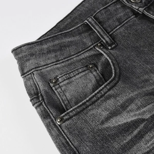 Gros plan sur la texture denim gris foncé avec rivets vintage et détails de poches