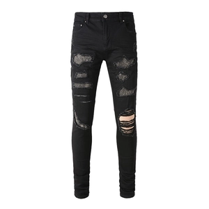 Men's black slim-fit denim jeans with stylish distressed ripped holes and sparkling rhinestones