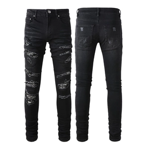 Men's black slim fit street style jeans featuring sequin patches and distressed holes