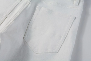 Detailed view of the back pocket and belt loops on white slim-fit stretch denim trousers