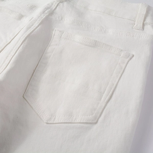 Macro shot of rear pocket and double stitching detail on white stretch denim jeans