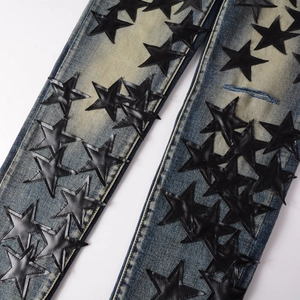 Slim fit dark blue washed jeans with black leather star patches and retro distressed details