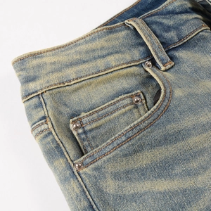 Detailed macro view of vintage washed blue denim pocket with metal rivets and reinforced stitching