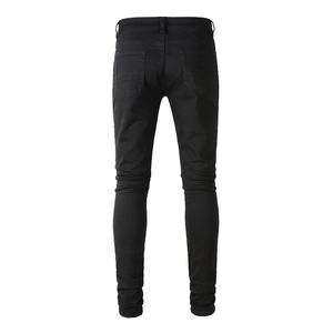 Rear view of black skinny distressed jeans for men showing pockets and stitching detail