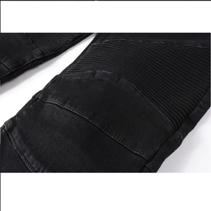 Detail shot of biker-style ribbed paneling on black slim-fit distressed moto denim jeans