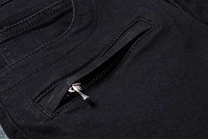 Dettaglio della tasca con cerniera argento nascosta sui jeans biker neri slim fit