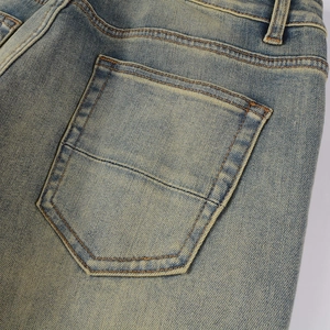 Detail of distressed light blue denim jeans showing rear pocket and reinforced stitching