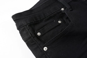 Détail de la poche avant et des rivets argentés sur un jean slim noir pour hommes