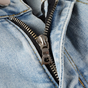 Détail macro du jean pour homme avec fermeture éclair métallique et bouton argenté