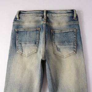 Détail du jean bleu clair montrant les poches arrière et la texture denim usée