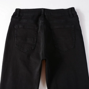 Close-up back view of black slim fit denim jeans showing rear pockets and belt loops