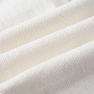 Detailed close-up of premium white stretch denim fabric with fine twill texture and softness