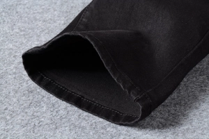 Dettaglio del tessuto twill di cotone pesante e delle cuciture rinforzate sui jeans neri