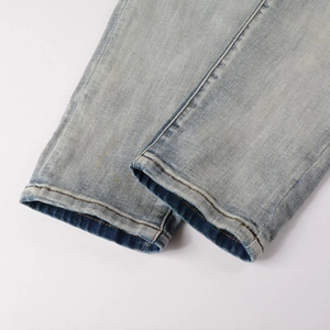 Macro shot of light blue washed denim jeans leg showing detailed stitching and fabric texture
