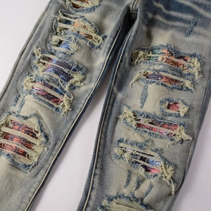 Jean slim stretch pour homme avec délavage vintage et patchs colorés sur zones usées