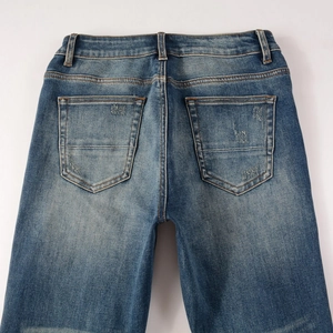Détail du jean vintage avec poches arrière et effets de patchwork délavés et usés