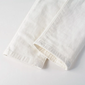 Detail view showing heavy-duty white denim fabric with precise topstitching and texture