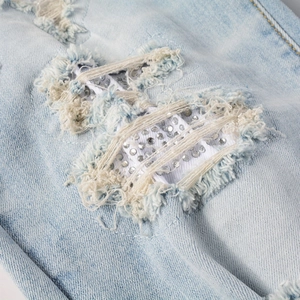 Macro de denim bleu clair avec détails déchirés et décorations en strass argentés