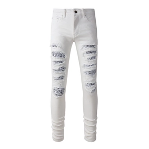 Jeans slim bianchi con toppe paisley blu e dettagli in denim strappato di tendenza
