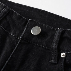 Close-up of metal button and stitching details on high-quality black denim jeans