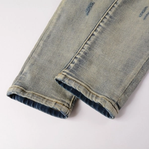 Gros plan d'un jean bleu clair délavé avec ourlet déchiré et détails de texture vintage