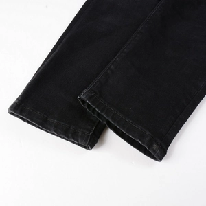 Men's black streetwear denim pants featuring detailed hem stitching and cashew flower patches