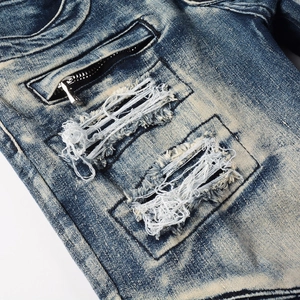 Detail of distressed vintage denim with cat-whisker wash and metal zipper pocket