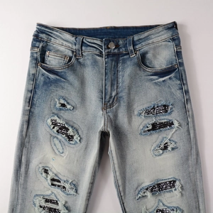 Men's distressed slim fit jeans with paisley patches and vintage washed blue denim texture