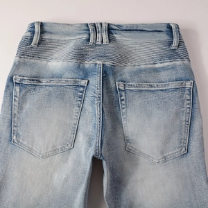 Vue détaillée du jean biker bleu clair montrant les plis arrière et la texture du denim