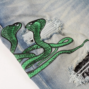 Jean bleu clair ajusté avec broderie cobra verte et détails usés de haute qualité