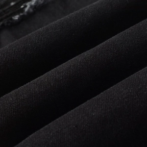 Close-up of black denim fabric with twill texture and matte finish for men's street jeans