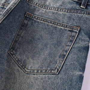 Détail du jean denim délavé bleu vintage avec coutures renforcées sur la poche arrière