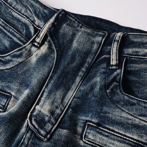 Close-up of vintage distressed denim waist with whiskers and heavy washing details