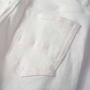 Dettaglio ravvicinato della tasca posteriore e cuciture dei jeans bianchi slim fit