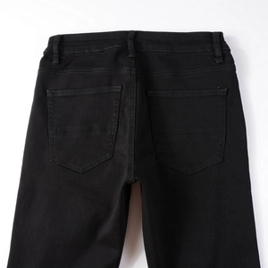 Detailed view of the back waist and symmetric pockets on slim fit black denim jeans