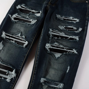 Slim fit distressed jeans in dark blue denim with patched holes and yellow stitching