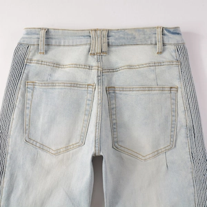 Detail view of light blue denim jeans showing rear pockets and striped elastic side panels