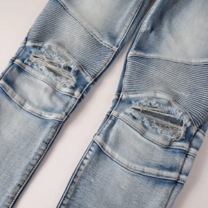 Détails du jean moto bleu clair avec plis aux genoux et effets de déchirures